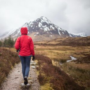 Hiker Walking on Trail Towards a Mountain